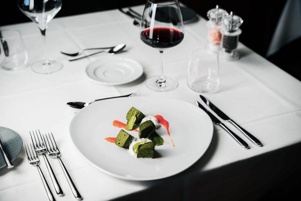 Piatto gourmet vegetariano servito al ristorante Plan Murin in Alta Badia con vino rosso